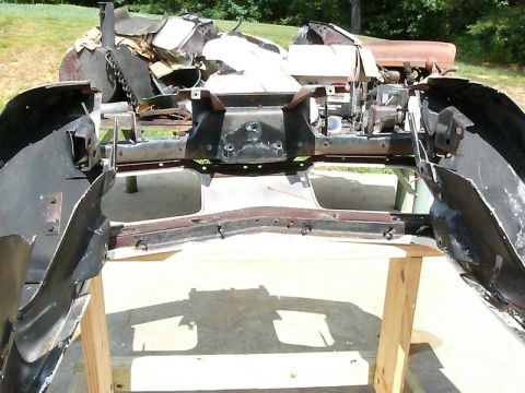1976 Chevrolet Corvette - The front end of a car, including bumper and frame components, is disassembled and laid out for repair or restoration.