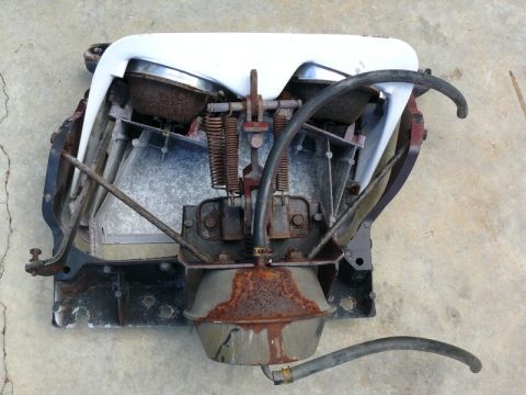 1976 Chevrolet Corvette - This is a car part, likely from a 1976 Chevrolet Corvette, with visible rust and hoses attached.