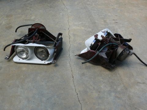 1976 Chevrolet Corvette - Two disassembled headlight assemblies, likely from a 1976 Chevrolet Corvette, are shown on a concrete floor.