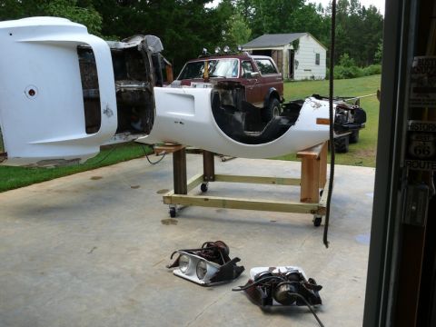 1976 Chevrolet Corvette - Body sections and headlights from a 1976 Chevrolet Corvette are laid out for work, with another vehicle in the background.