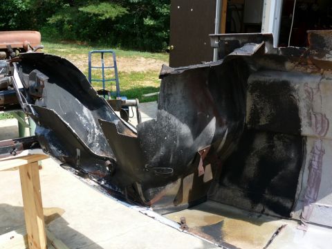 1976 Chevrolet Corvette - The photo shows disassembled car body parts and frame components resting on sawhorses outdoors.