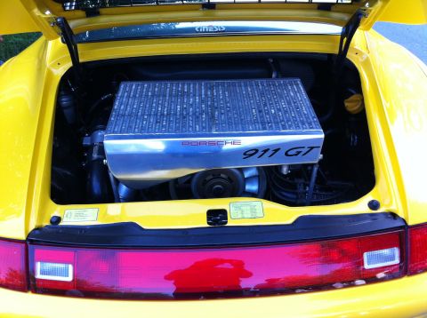 2010 Ford Falcon - The engine bay of a yellow Porsche 911 GT, the prominent intercooler cover and rear taillight assembly.