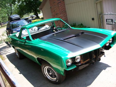 1971 Ford Ranchero - A green 1970 Ford Ranchero is parked outside a brick building, with another vehicle visible behind it.
