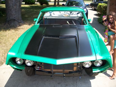 1971 Ford Ranchero - Front view of a green 1971 Ford Ranchero with a black hood scoop and missing grille.