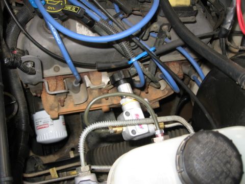 1995 Ford Bronco - Close-up view of an engine bay, highlighting a brake proportioning valve and associated plumbing.