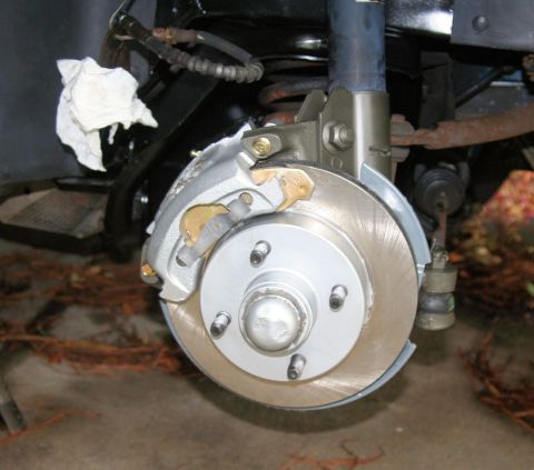 1980 Ford Mustang - Close-up view of a vehicle's front brake assembly, showing the caliper and rotor.