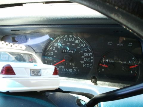 1998 Ford Crown Victoria - Interior view of a dashboard displaying mileage and a toy car on the left.