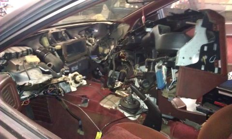 1987 Mazda RX-7 - The interior of a 1987 Mazda RX-7 is shown with the dashboard removed, revealing complex wiring and components.