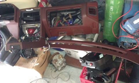 1987 Mazda RX-7 - A disassembled brown dashboard interior reveals exposed wiring and various components, suggesting a project in progress.