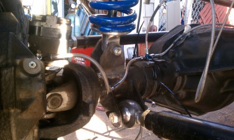 1990 Ford Bronco - Detail shot of vehicle suspension and axle components, with a Lincoln Electric welder visible.