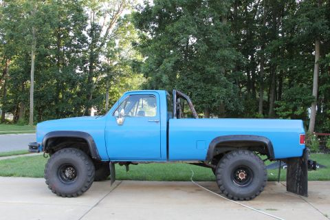 1978 Chevrolet C/K Pickup - This blue 1978 Chevrolet C/K Pickup features oversized tires and a roll bar, suggesting off-road modifications.