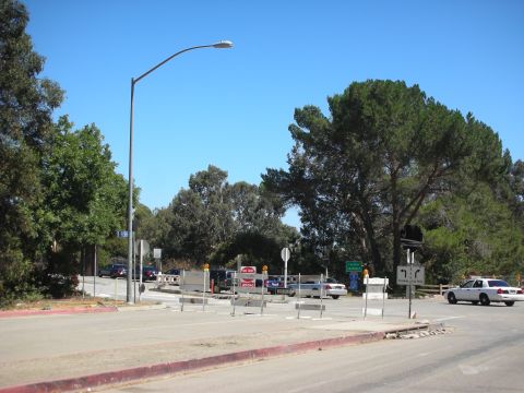 2004 Ford Crown Victoria - A police car is visible near traffic barriers and signs at a road intersection on a clear day.