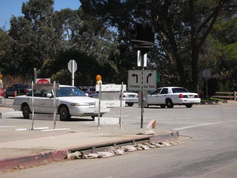 2004 Ford Crown Victoria - Two white sedans are visible at a road intersection with directional signage.