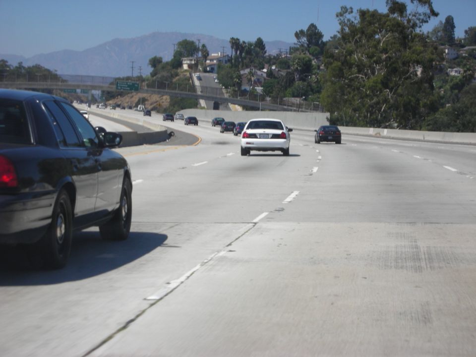 Black police car side view on highway