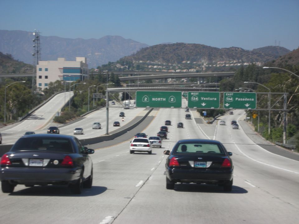 Dark blue Ford Crown Victoria from rear, driving on a highway
