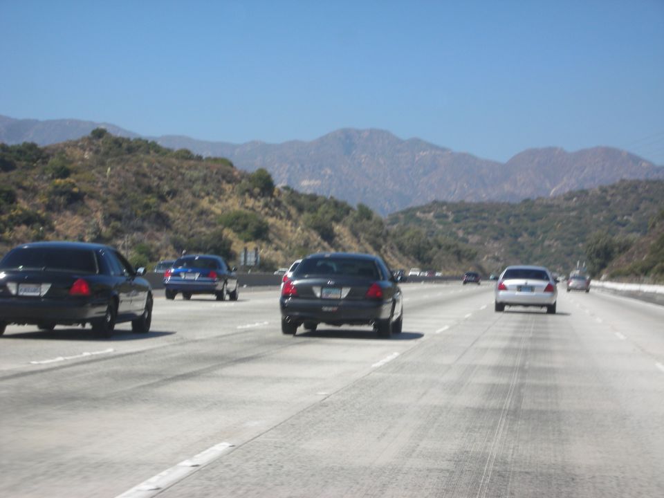 Black 2004 Ford Crown Victoria on highway, rear view
