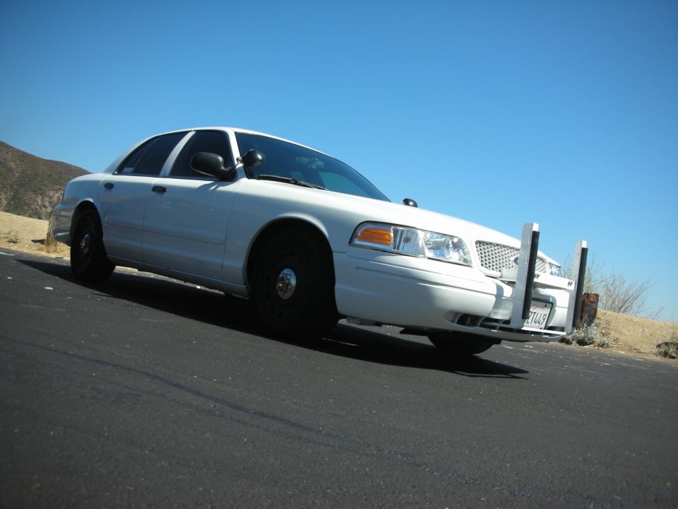 White police car with push bumper and California license plate 7T449 parked on asphalt