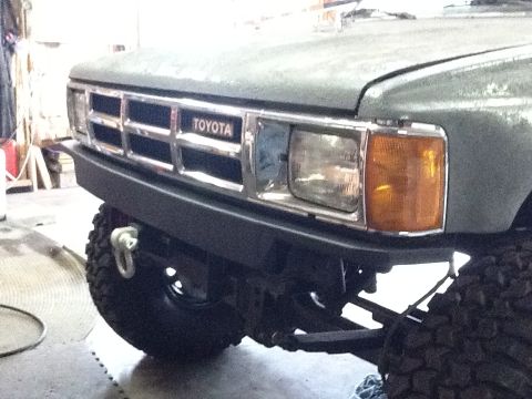 1988 Suzuki Samurai - Close-up of a Toyota truck's front grille and bumper, showing the 'TOYOTA' emblem and off-road modifications.