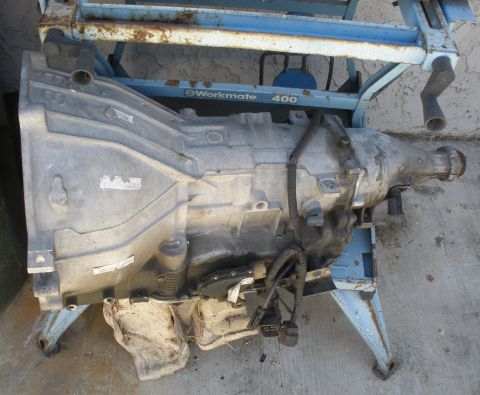 1995 Ford Thunderbird - An automatic transmission is shown mounted on a blue metal stand.