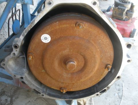 1995 Ford Thunderbird - A rusty torque converter is visible inside a transmission housing, a "Quality Remanufacture" sticker.