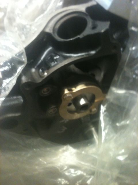 1993 Ford Bronco - Close-up of an engine component, possibly a water pump, in plastic packaging.
