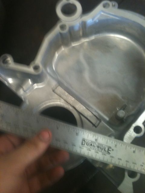 1993 Ford Bronco - Measuring an engine component with a ruler. The part is made of aluminum.