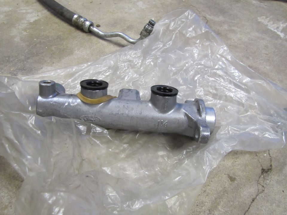 Ford brake master cylinder with "1 1/4" stamped on it, next to a hose