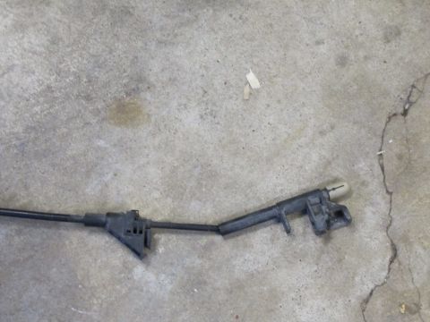 1995 Ford Bronco - A close-up view of an automotive cable assembly lying on a concrete surface.