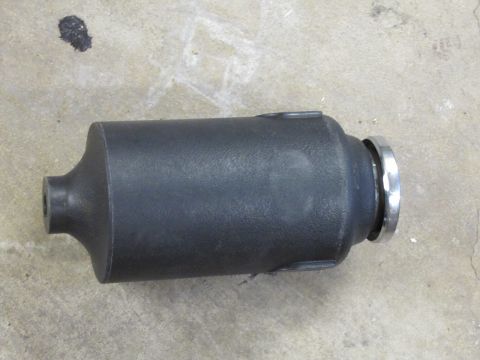 1995 Ford Bronco - A black cylindrical automotive part with silver trim is shown against a concrete background.
