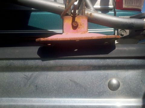1996 Ford Bronco - A close-up view of a rusty high lift jack base mounted on a vehicle's exterior.