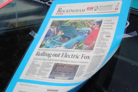 2007 Ford Mustang - Photograph of a newspaper page about an electric Fox-body Mustang displayed on a windshield.