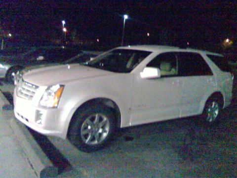 2006 Ford E350 - White Cadillac SRX parked at night, likely a 2004 model based on its body style.
