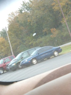 1997 Ford Taurus - A blue 1997 Ford Taurus is parked in a lot with other vehicles visible.