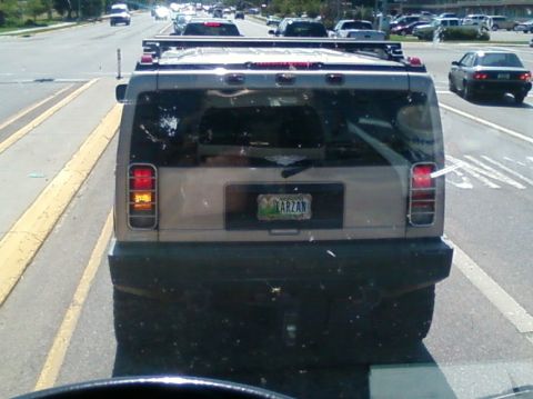 2006 Ford E350 - The rear of a Hummer H2 is seen driving on a road, displaying a personalized license plate.