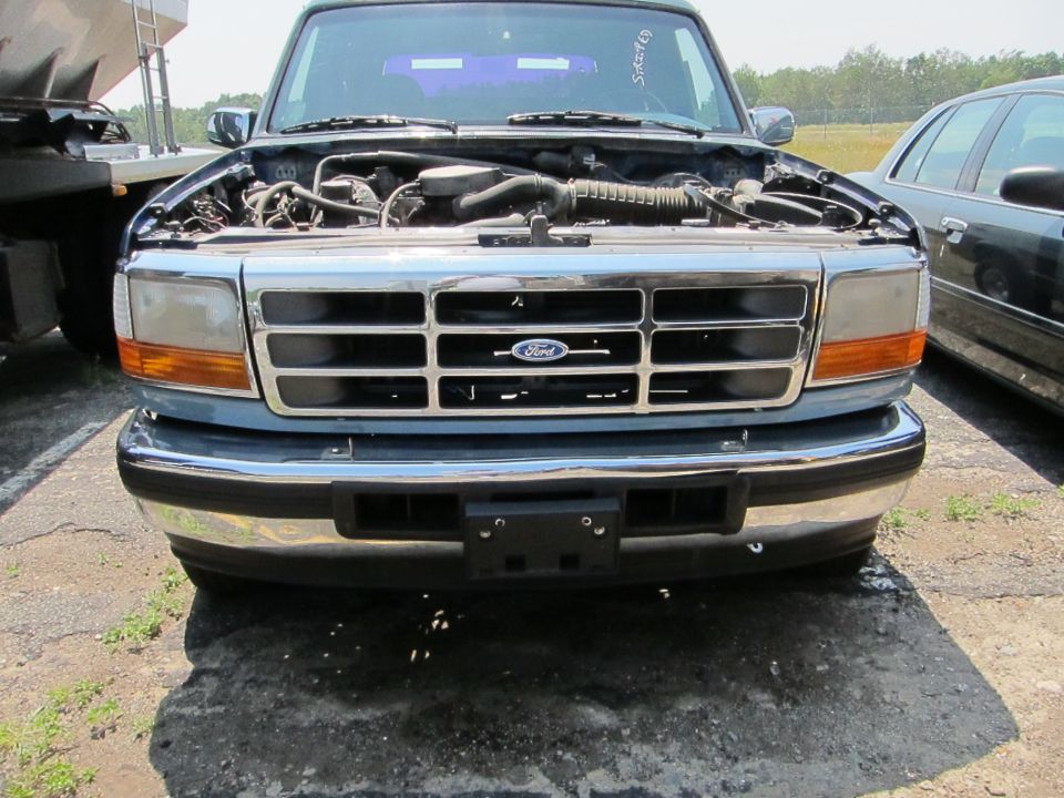 Front view of a blue 1995 Ford F-Series truck with hood open