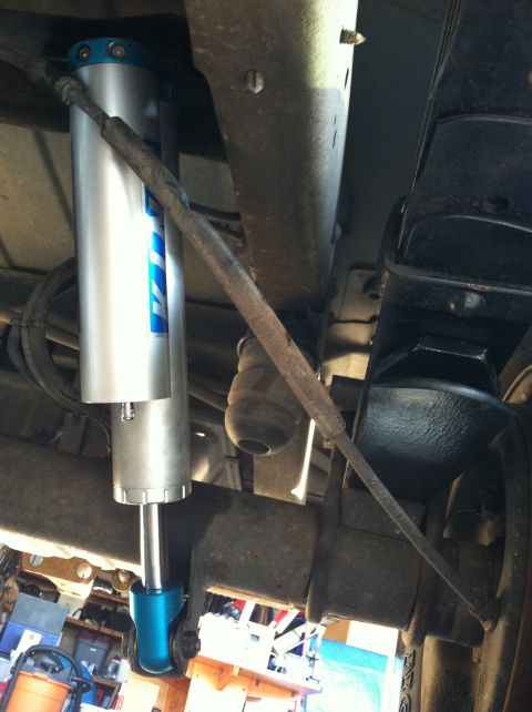 1991 Ford E250 - Close-up view of the rear suspension system, showing a shock absorber and other components.