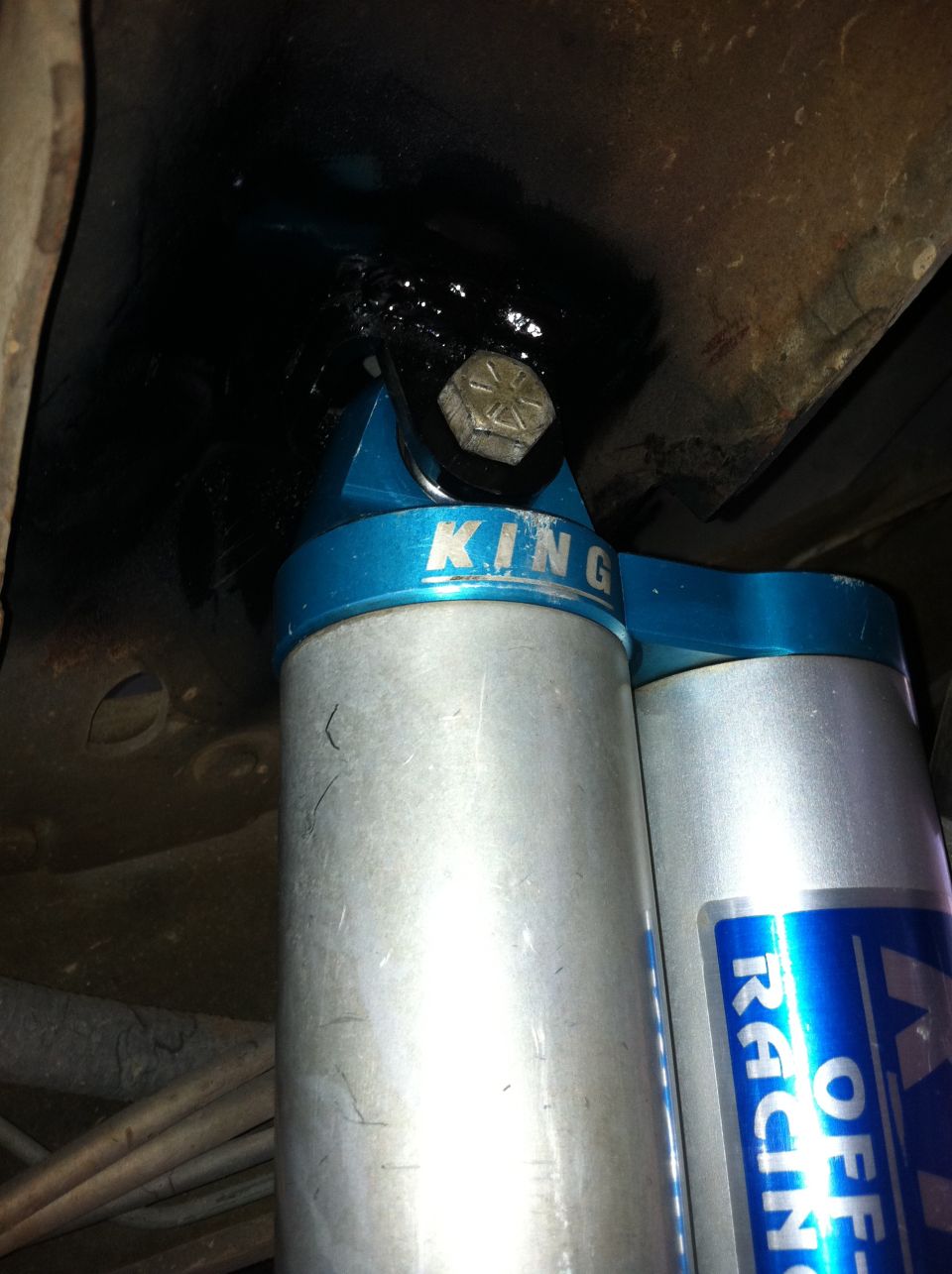 Blue and silver King Off-Road shock absorber with visible bolt and mounting bracket