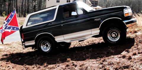 1993 Ford Bronco - Black and white 1993 Ford Bronco with a Confederate flag mounted on the back.