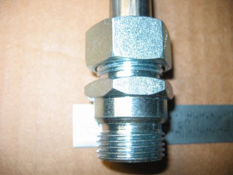 1992 Ford Bronco - A metal fitting with threaded end and hex nuts is shown, with a ruler for scale.