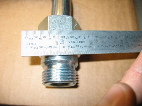 1992 Ford Bronco - A metal fitting is measured with a ruler, indicating its dimensions.