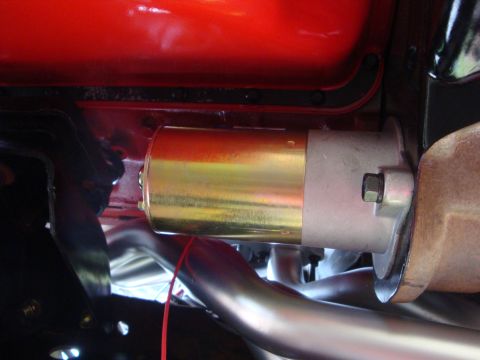 1989 Ford Bronco - Close-up view of a vehicle's starter motor and exhaust system components.