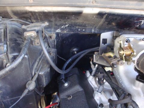 1989 Ford Bronco - Close-up view of engine bay components, including hoses and throttle linkage.