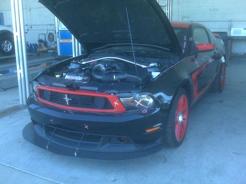 1973 Ford Mustang - This modern Ford Mustang features a black body with red accents and bright red wheels, its hood raised to reveal the engine.