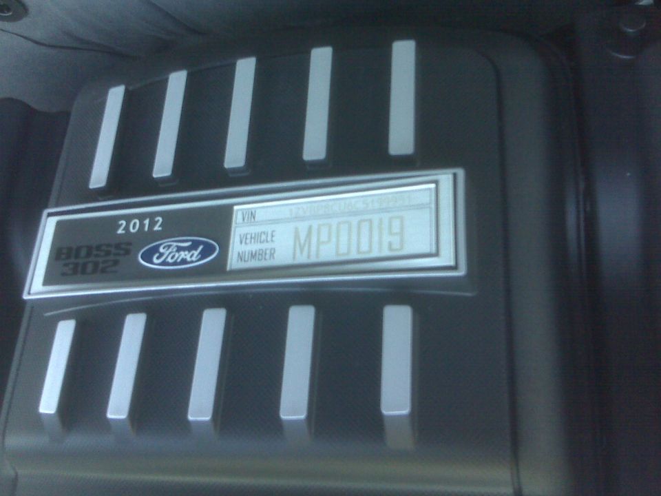 Close-up of 2012 Ford Mustang Boss 302 engine cover with VIN plate
