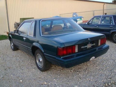 1991 Ford LTD Crown Victoria - Rear view of a dark teal sedan, vertical taillights and a Chevrolet emblem on the trunk.