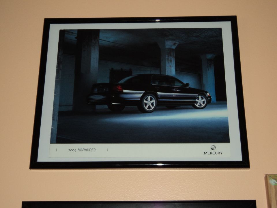 Framed Mercury factory print of a black 2004 Marauder sedan in a dim concrete garage