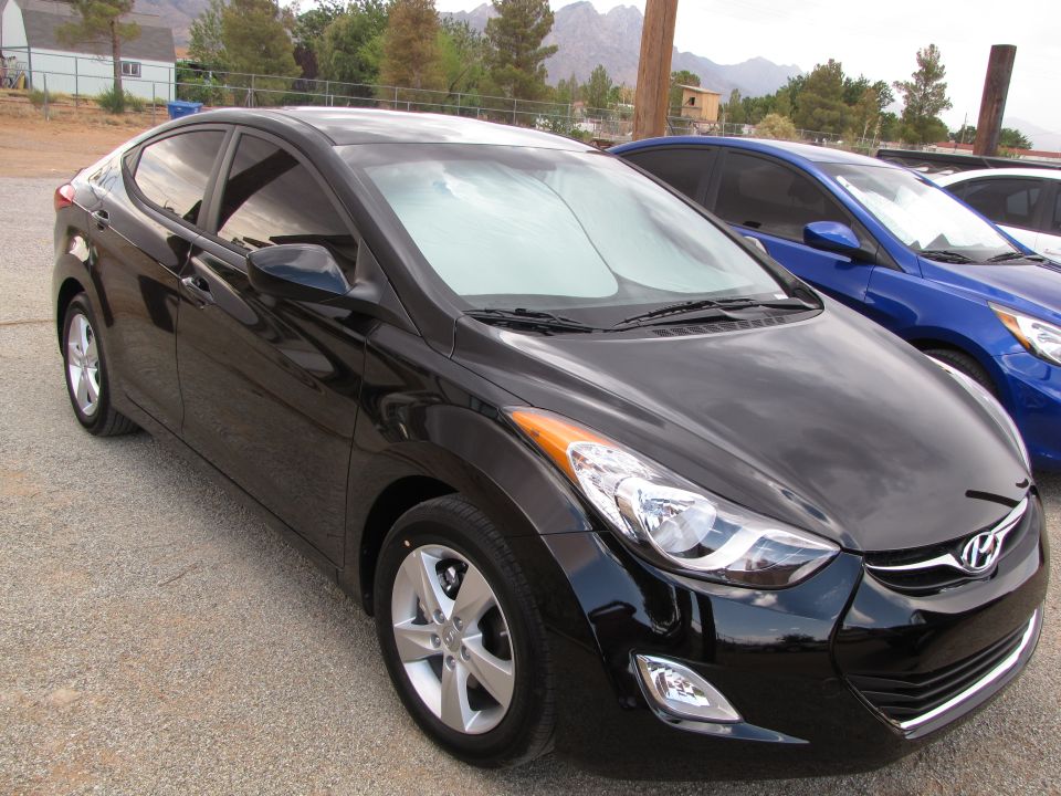 Black Hyundai Elantra parked outside with a blue car behind it