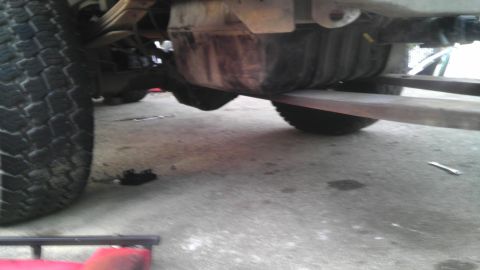1989 Ford Bronco - Close-up view of the undercarriage of a vehicle, focusing on the rear axle and suspension components.