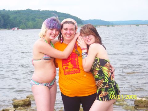 1989 Ford Bronco - Three friends smile for a photo on a rocky shore with a dam and trees in the background.