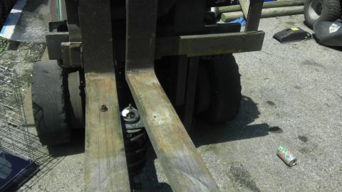 2007 Dodge Caliber - Close-up view of a forklift's forks and a tire on asphalt.